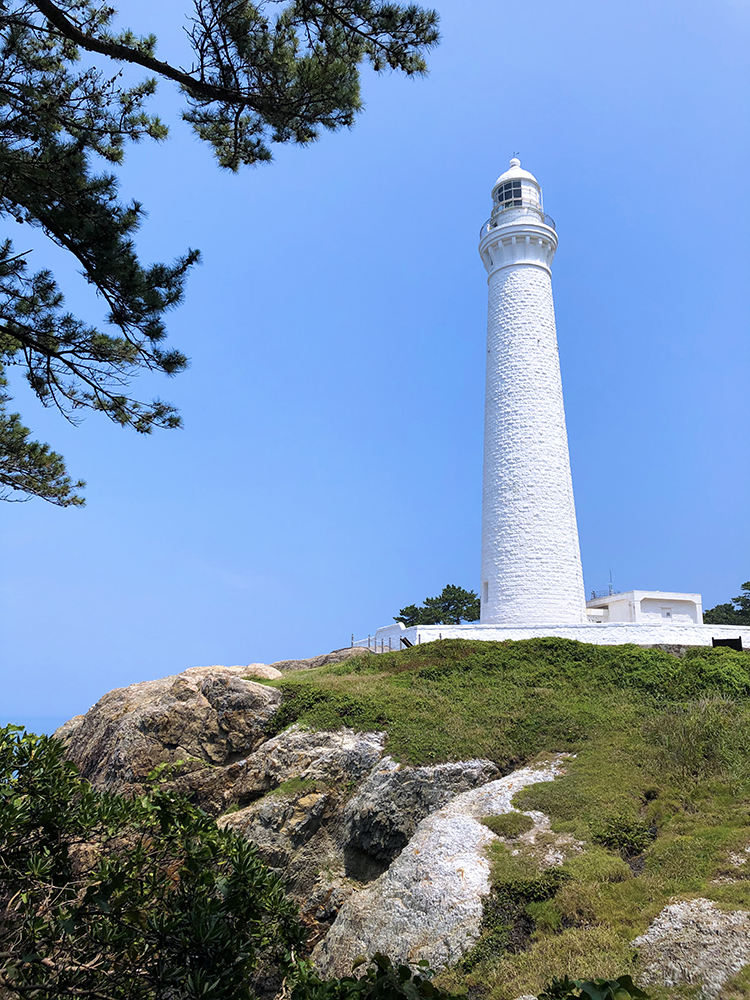 Stark white lighthouse on the rocky coast of Hinomisaki